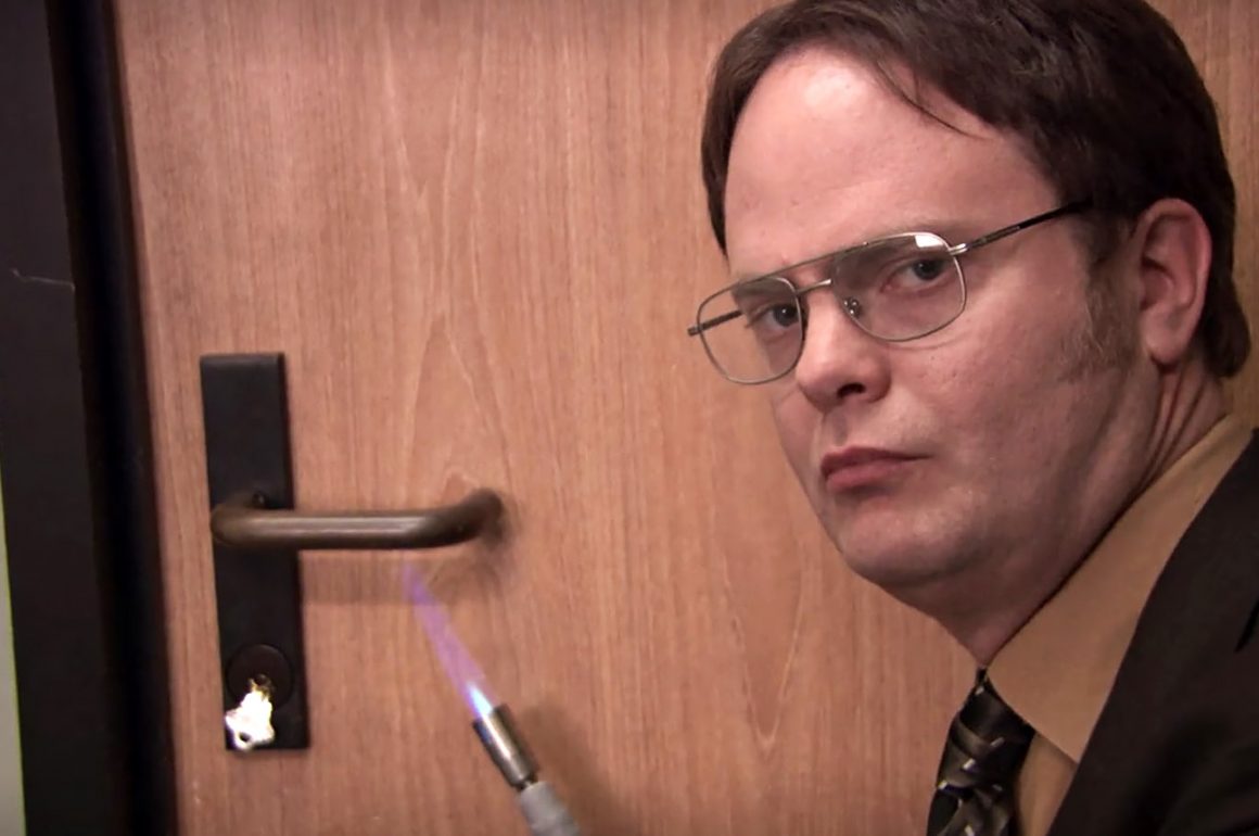 Dwight from The Office heating up a door handle with a torch