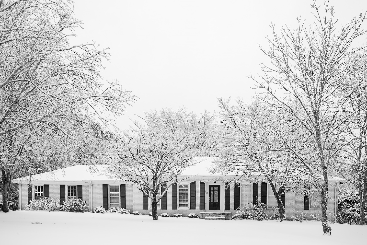 suburban ranch home with snow